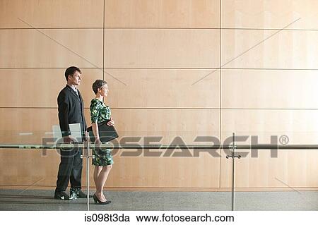 Businesspeople walking through corridor View Large Photo Image Stock Image - Businesspeople walking through corridor. Fotosearch