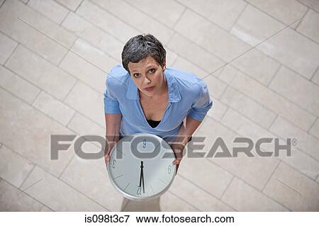 Businesswoman holding clock View Large Photo Image Stock Photo - Businesswoman holding clock. Fotosearch