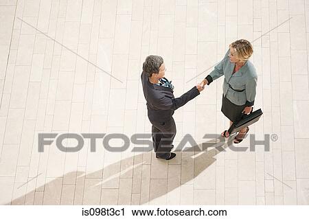 Stock Image - Businesswomen shaking hands. Fotosearch