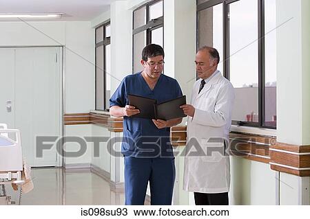 Doctor and surgeon looking at file View Large Photo Image Stock Image - Doctor and surgeon looking at file. Fotosearch