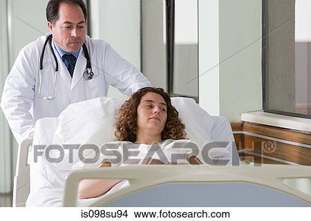 Doctor pushing patient in bed View Large Photo Image Picture - Doctor pushing patient in bed. Fotosearch