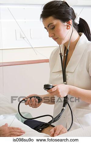 Nurse using blood pressure gauge on patient View Large Photo Image Picture - Nurse using blood pressure gauge on patient. Fotosearch
