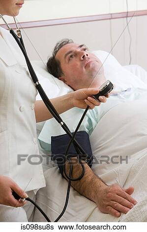 Stock Photograph - Nurse using blood pressure gauge on patient. Fotosearch