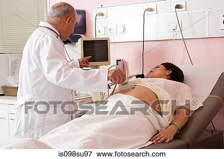 Pregnant woman having ultrasound scan View Large Photo Image Stock Photo - Pregnant woman having ultrasound scan. Fotosearch