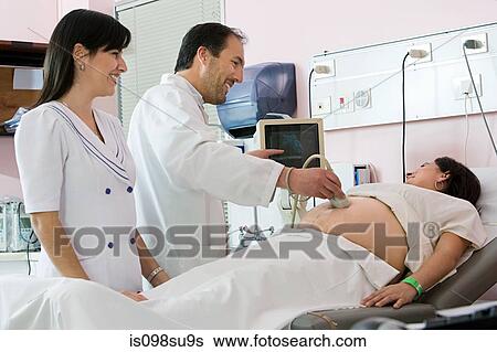 Pregnant woman having ultrasound scan View Large Photo Image Stock Photograph - Pregnant woman having ultrasound scan. Fotosearch