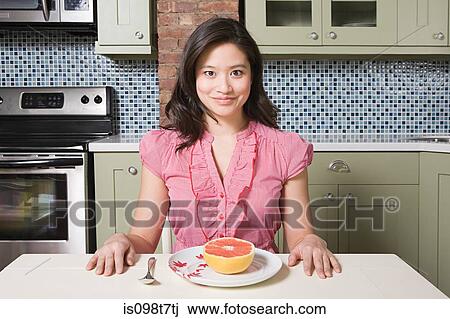 Young woman eating grapefruit View Large Photo Image Stock Image - Young woman eating grapefruit. Fotosearch