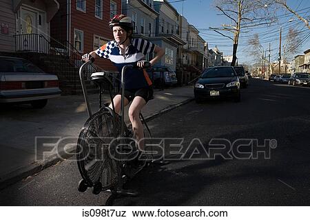 Stock Photo - Young woman on exercise bike. Fotosearch