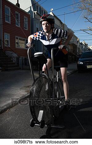 Young woman on exercise bike View Large Photo Image Stock Photograph - Young woman on exercise bike. Fotosearch