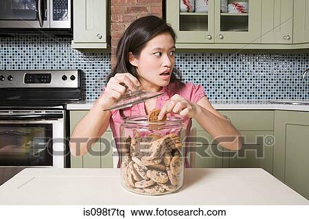 Young woman with cookie jar View Large Photo Image Stock Photography - Young woman with cookie jar. Fotosearch