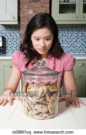 Stock Photography - Young woman with cookie jar. Fotosearch