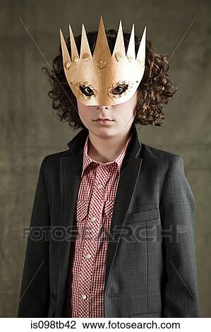 Stock Image - Young boy wearing gold crown mask. Fotosearch