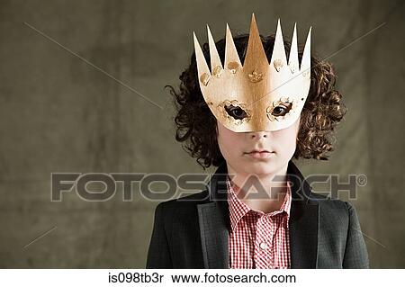 Stock Photography - Young boy wearing gold crown mask. Fotosearch