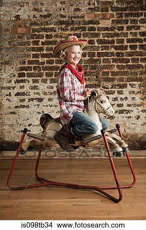 Young girl dressed as cowgirl with rocking horse View Large Photo Image Picture - Young girl dressed as cowgirl with rocking horse. Fotosearch