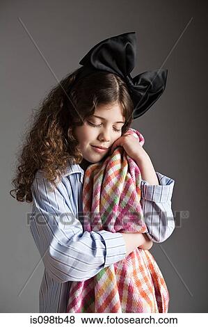 Young girl dressed in pyjamas with black hair bow, holding comfort blanket View Large Photo Image Stock Photo - Young girl dressed in pyjamas with black hair bow, holding comfort blanket. Fotosearch