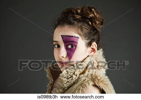 Stock Image - Young girl wearing purple face paint. Fotosearch