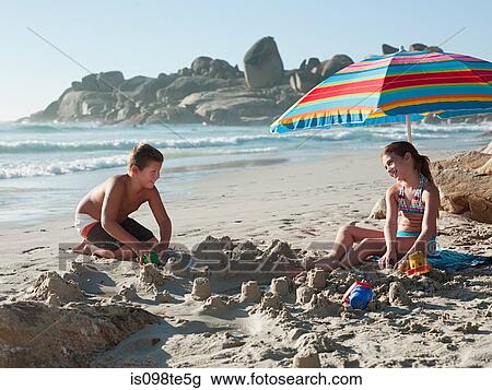 Boy and girl making sandcastles on beach View Large Photo Image Stock Image - Boy and girl making sandcastles on beach. Fotosearch