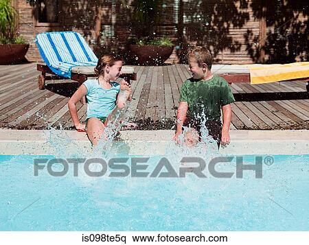 Boy and girl splashing in swimming pool View Large Photo Image Stock Photography - Boy and girl splashing in swimming pool. Fotosearch