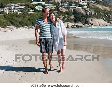 Stock Image - Couple walking on beach. Fotosearch