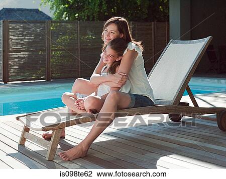 Girl and mother on lounge chair by swimming pool View Large Photo Image Stock Image - Girl and mother on lounge chair by swimming pool. Fotosearch