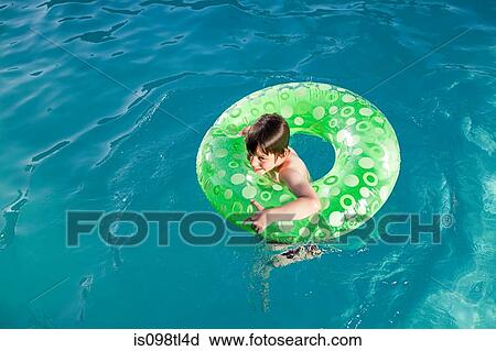 Boy in inflatable ring in outdoor swimming pool View Large Photo Image Stock Image - Boy in inflatable ring in outdoor swimming pool. Fotosearch