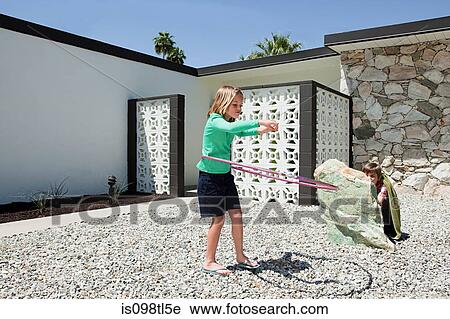Brother hiding behind rock watching sister with hoola hoop View Large Photo Image Stock Image - Brother hiding behind rock watching sister with hoola hoop. Fotosearch