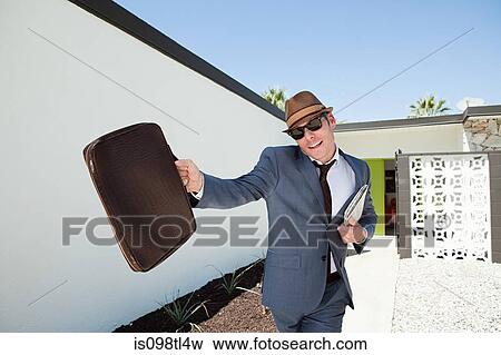 Confident businessman with briefcase and trilby View Large Photo Image Stock Photo - Confident businessman with briefcase and trilby. Fotosearch