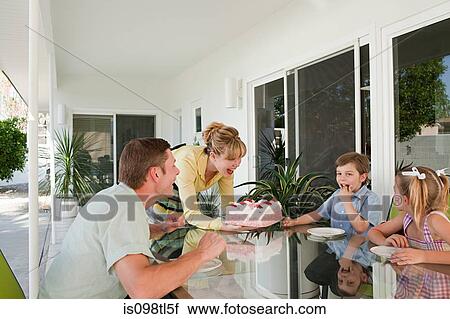 Stock Image - Family having birthday cake. Fotosearch
