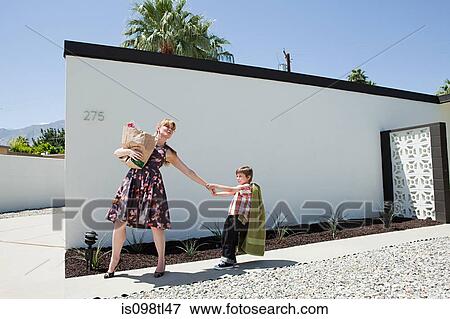 Mother holding shopping bag and pulling son's arm View Large Photo Image Stock Photo - Mother holding shopping bag and pulling son's arm. Fotosearch