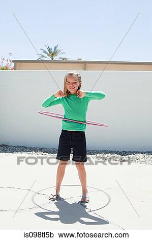 Stock Image - Young girl with hoola hoop. Fotosearch