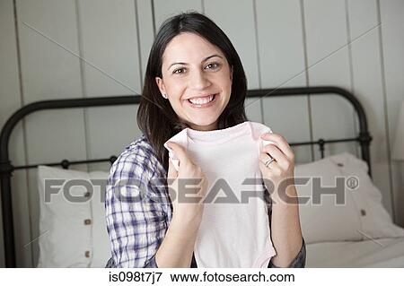 Expectant mother holding babygro View Large Photo Image Stock Photo - Expectant mother holding babygro. Fotosearch