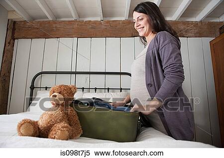Expectant mother packing suitcase View Large Photo Image Stock Photography - Expectant mother packing suitcase. Fotosearch