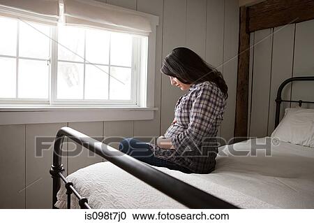 Expectant mother sitting on bed View Large Photo Image Stock Image - Expectant mother sitting on bed. Fotosearch