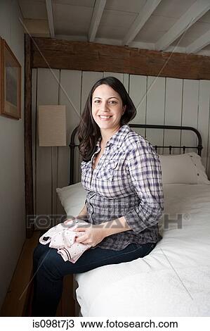 Expectant mother sitting on bed View Large Photo Image Stock Image - Expectant mother sitting on bed. Fotosearch