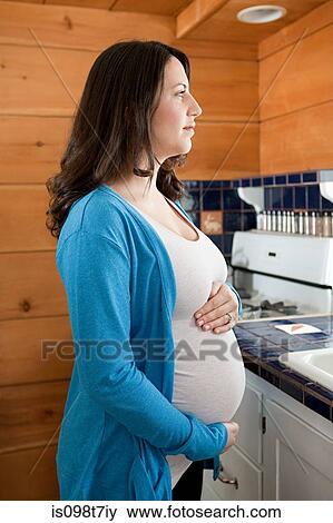 Pregnant woman in kitchen View Large Photo Image Stock Photo - Pregnant woman in kitchen. Fotosearch