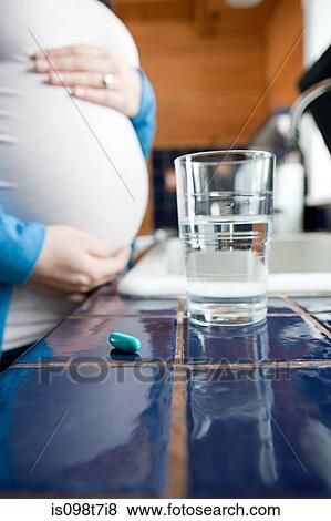 Pregnant woman with water and vitamin pills View Large Photo Image Stock Photo - Pregnant woman with water and vitamin pills. Fotosearch