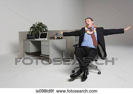 Stock Image - Businessman messing around on office chair. Fotosearch