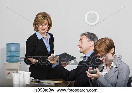 Businesswoman sitting on desk talking View Large Photo Image Stock Photo - Businesswoman sitting on desk talking. Fotosearch