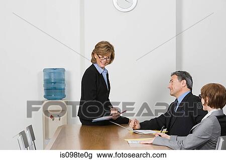 Businesswoman sitting on table talking View Large Photo Image Stock Image - Businesswoman sitting on table talking. Fotosearch