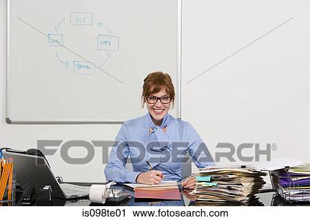 Businesswoman working at desk View Large Photo Image Stock Image - Businesswoman working at desk. Fotosearch