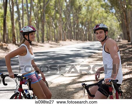 Stock Photo - Young couple cycling in forest. Fotosearch