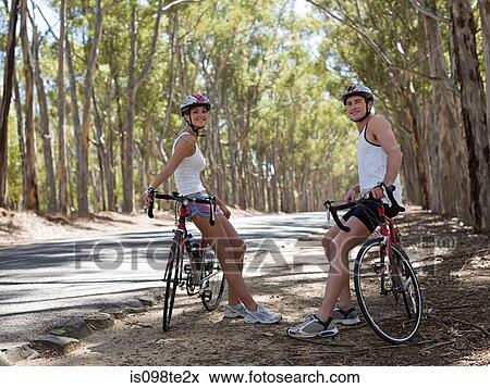 Young couple cycling in forest View Large Photo Image Stock Photo - Young couple cycling in forest. Fotosearch