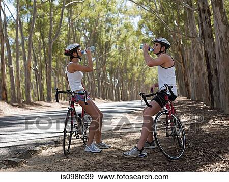 Stock Photo - Young couple cycling in forest. Fotosearch