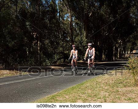 Young couple cycling on road View Large Photo Image Picture - Young couple cycling on road. Fotosearch