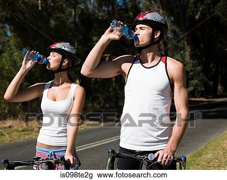 Young couple cycling on road View Large Photo Image Stock Image - Young couple cycling on road. Fotosearch