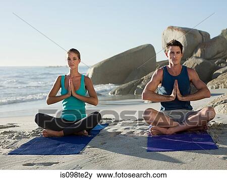 Young couple doing yoga on beach View Large Photo Image Stock Photo - Young couple doing yoga on beach. Fotosearch