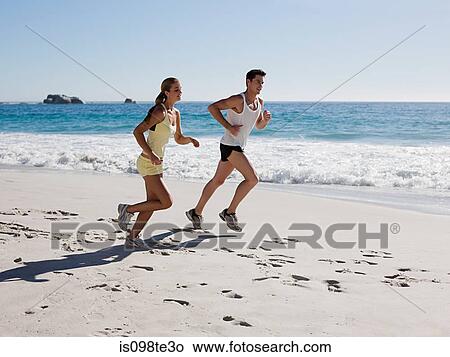 Picture - Young couple jogging on beach. Fotosearch