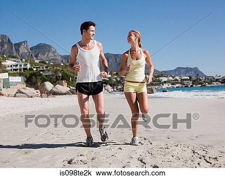Young couple jogging on beach View Large Photo Image Stock Image - Young couple jogging on beach. Fotosearch