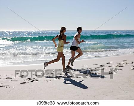 Young couple jogging on beach View Large Photo Image Stock Image - Young couple jogging on beach. Fotosearch