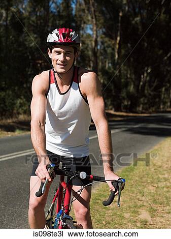 Young man cycling on road View Large Photo Image Stock Image - Young man cycling on road. Fotosearch