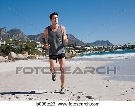 Young man jogging on beach View Large Photo Image Stock Image - Young man jogging on beach. Fotosearch